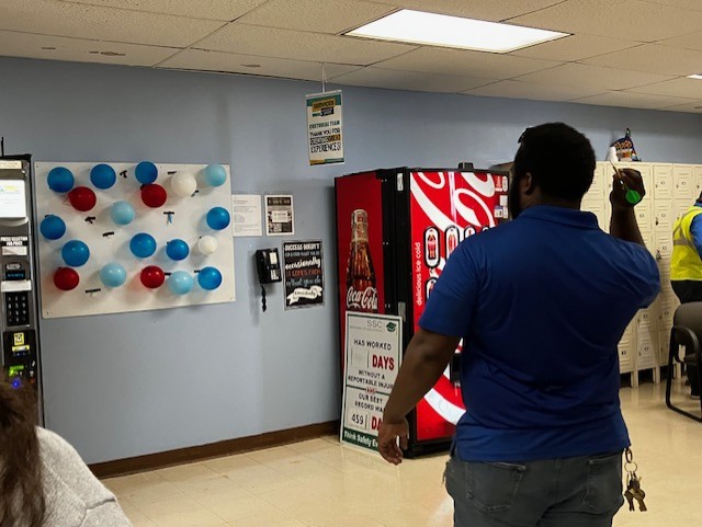 A photo of a student at Texas A&M University Corpus Christi putting together a balloon dart board filled with prizes